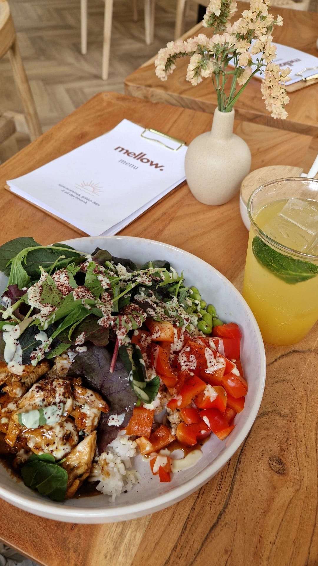 Bunte Bowl mit Limonade und Speisekarte auf einem Holztisch im mellow.