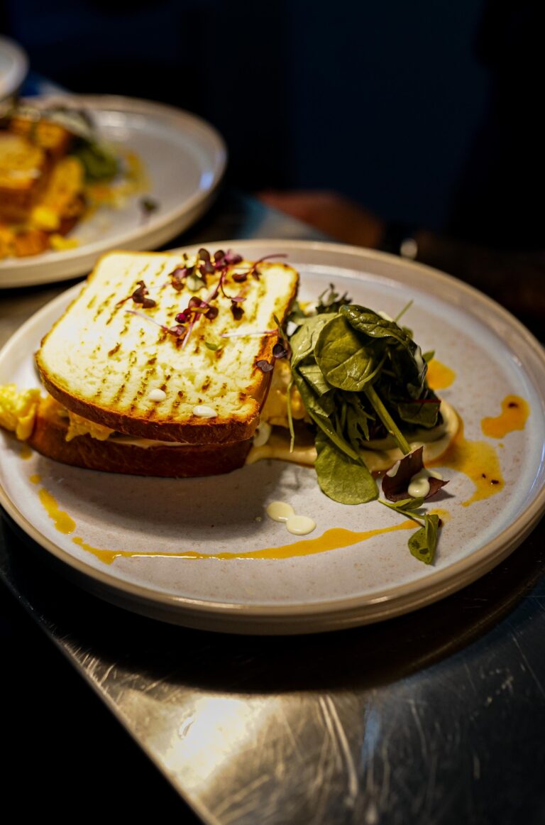 Gegrilltes Sandwich mit Blattsalat auf einem Teller im mellow.